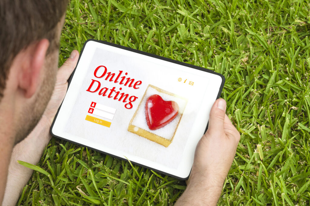 Man using tablet for online dating while relaxing outdoors