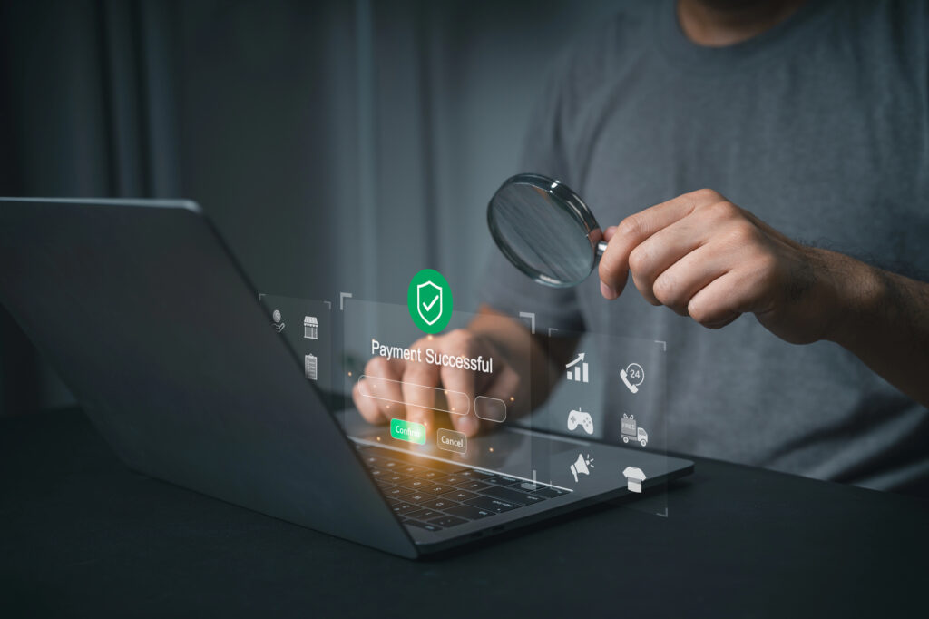 Hand using laptop confirming successful online payment transaction security